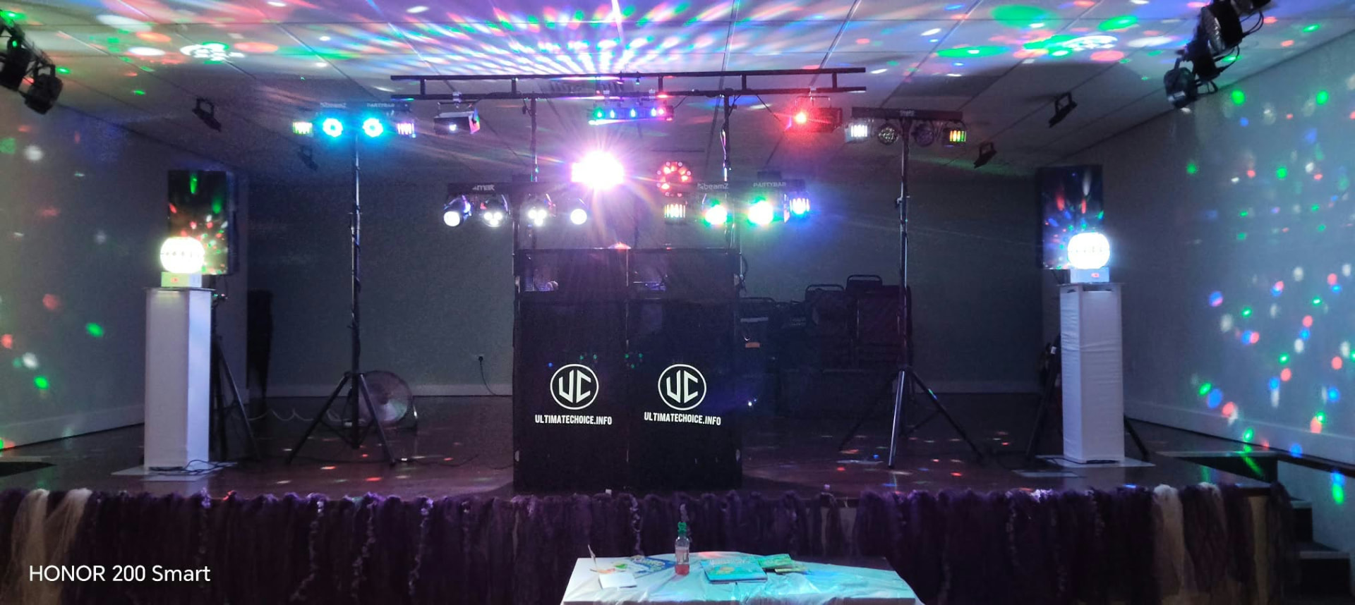 Ultimate Choices DJ booth and lighting rig set up on a stage ready for the night